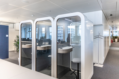 A row of individual work pods with seating and desk spaces inside